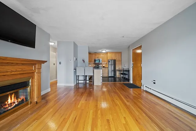 a view of empty room with wooden floor and fireplace