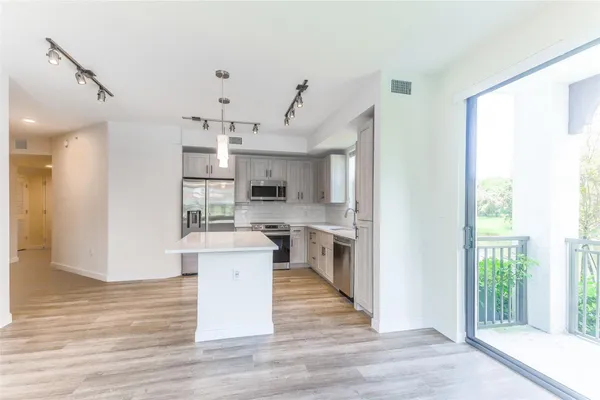 a view of a kitchen with cabinets and wooden floor