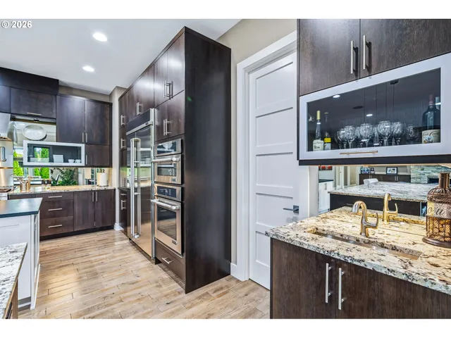 a kitchen with stainless steel appliances kitchen island granite countertop a refrigerator and cabinets