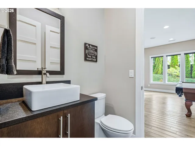 a bathroom with a sink a toilet and a large mirror