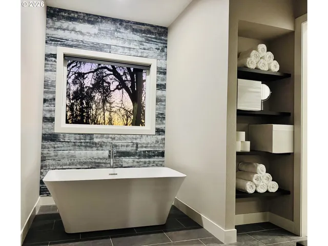 a white bath tub sitting in a bathroom next to a window