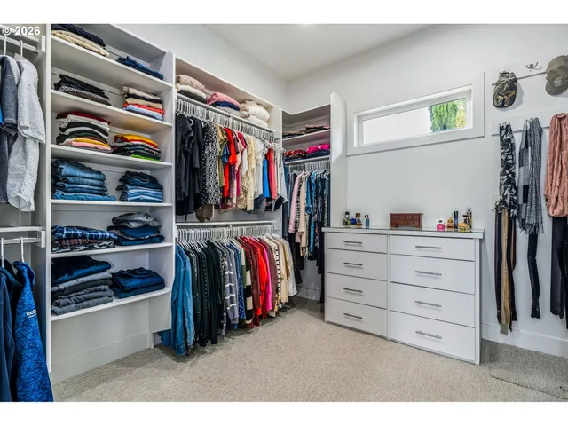 a view of walk in closet with clothes and shoes