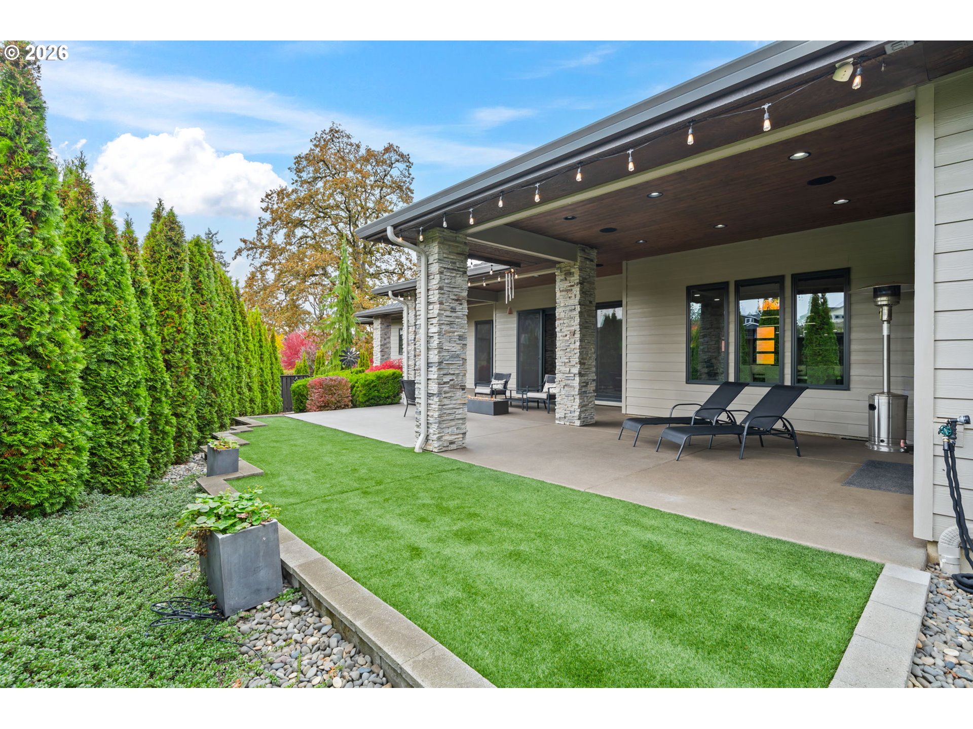 1203 South Great Blue Road Ridgefield, WA 98642 - Photo 40 of 48 a view of a patio with table and chairs potted plants and floor to ceiling window