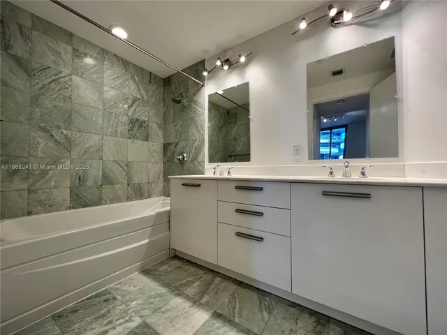 a bathroom with a double vanity sink mirror and toilet
