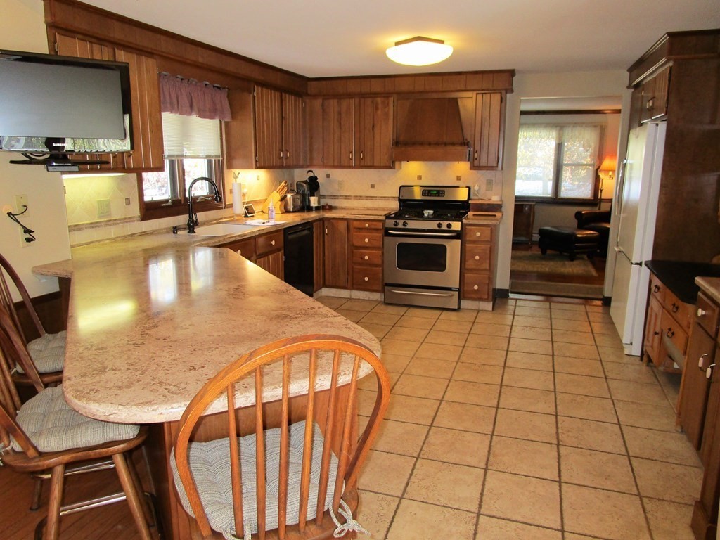 1209 Amostown Road West Springfield, MA 01089 - Photo 3 of 29 a kitchen with stainless steel appliances granite countertop a stove a sink a microwave and a refrigerator