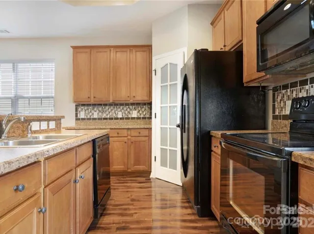 a kitchen with stainless steel appliances granite countertop a refrigerator stove and sink