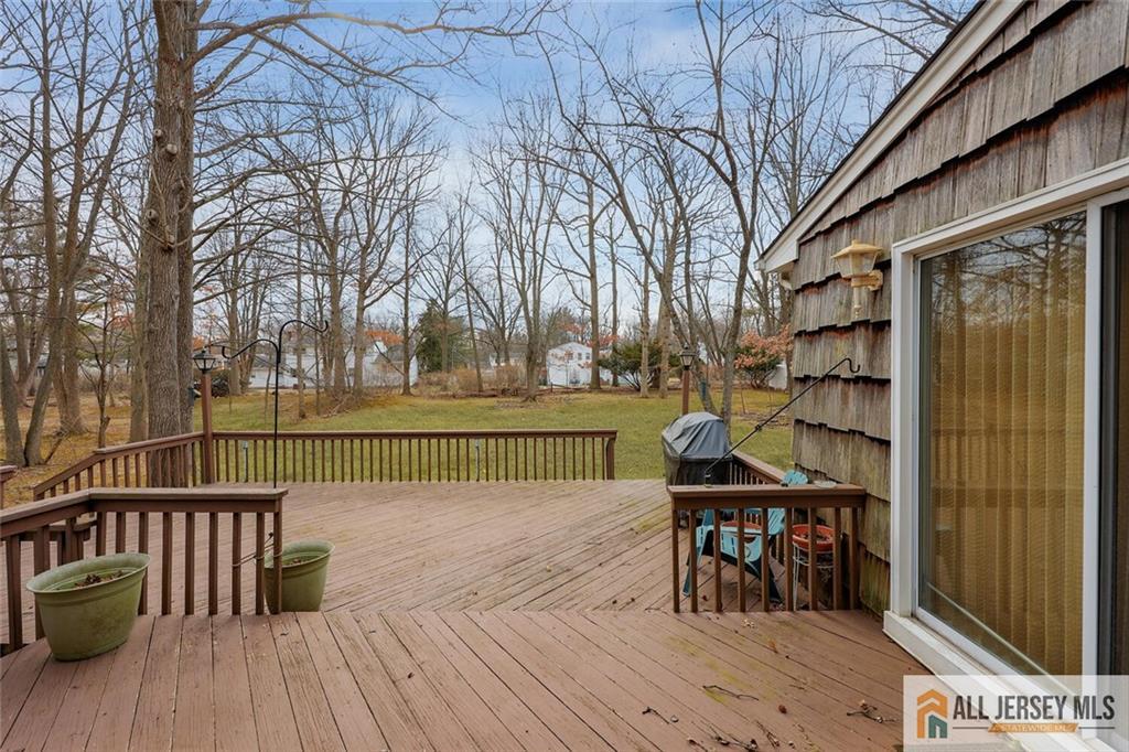 9 Woodruff Road Edison, NJ 08820 - Photo 31 of 39 a view of a roof deck with table and chairs a barbeque with wooden floor and fence