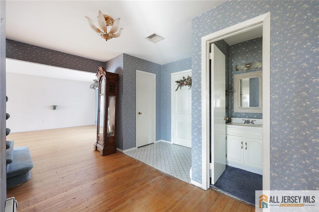 9 Woodruff Road Edison, NJ 08820 - Photo 6 of 39 a view of a hallway with wooden floor and cabinet