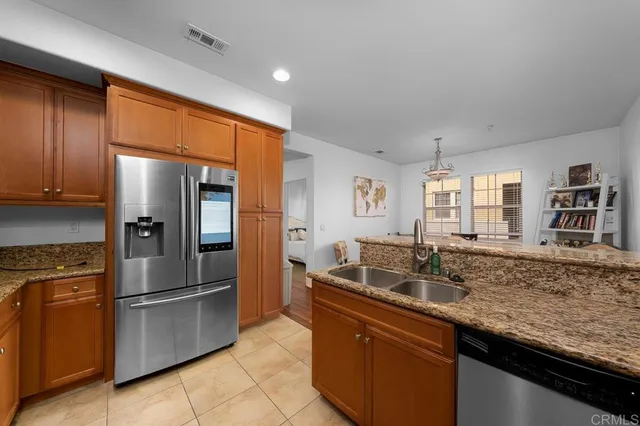 a kitchen with stainless steel appliances granite countertop a refrigerator and a sink
