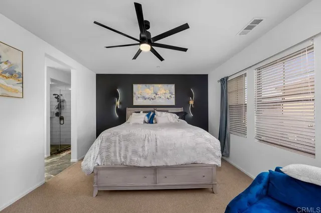 a spacious bedroom with a bed and a chandelier