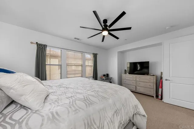 a bedroom with a large bed and a flat screen tv