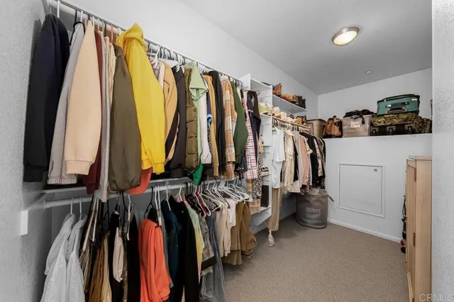 a view of walk in closet with clothes and shoes