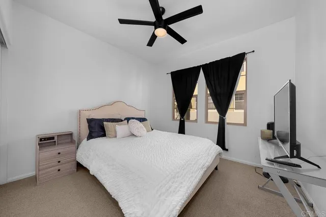 a bedroom with bed tv and window