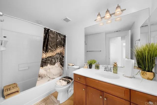 a bathroom with a granite countertop sink a toilet and a shower