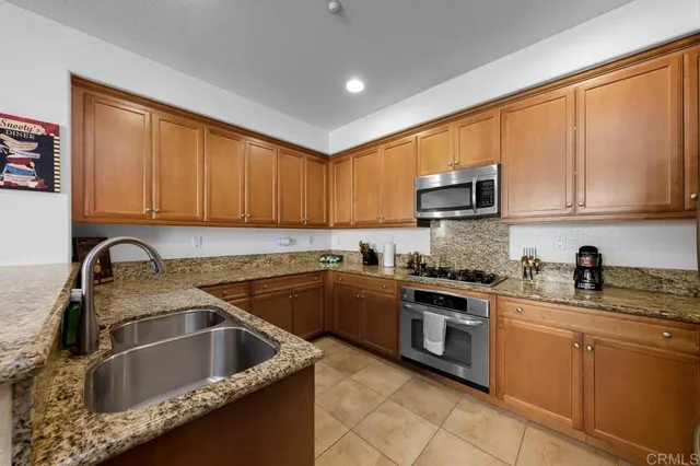 a kitchen with granite countertop a sink stainless steel appliances and cabinets
