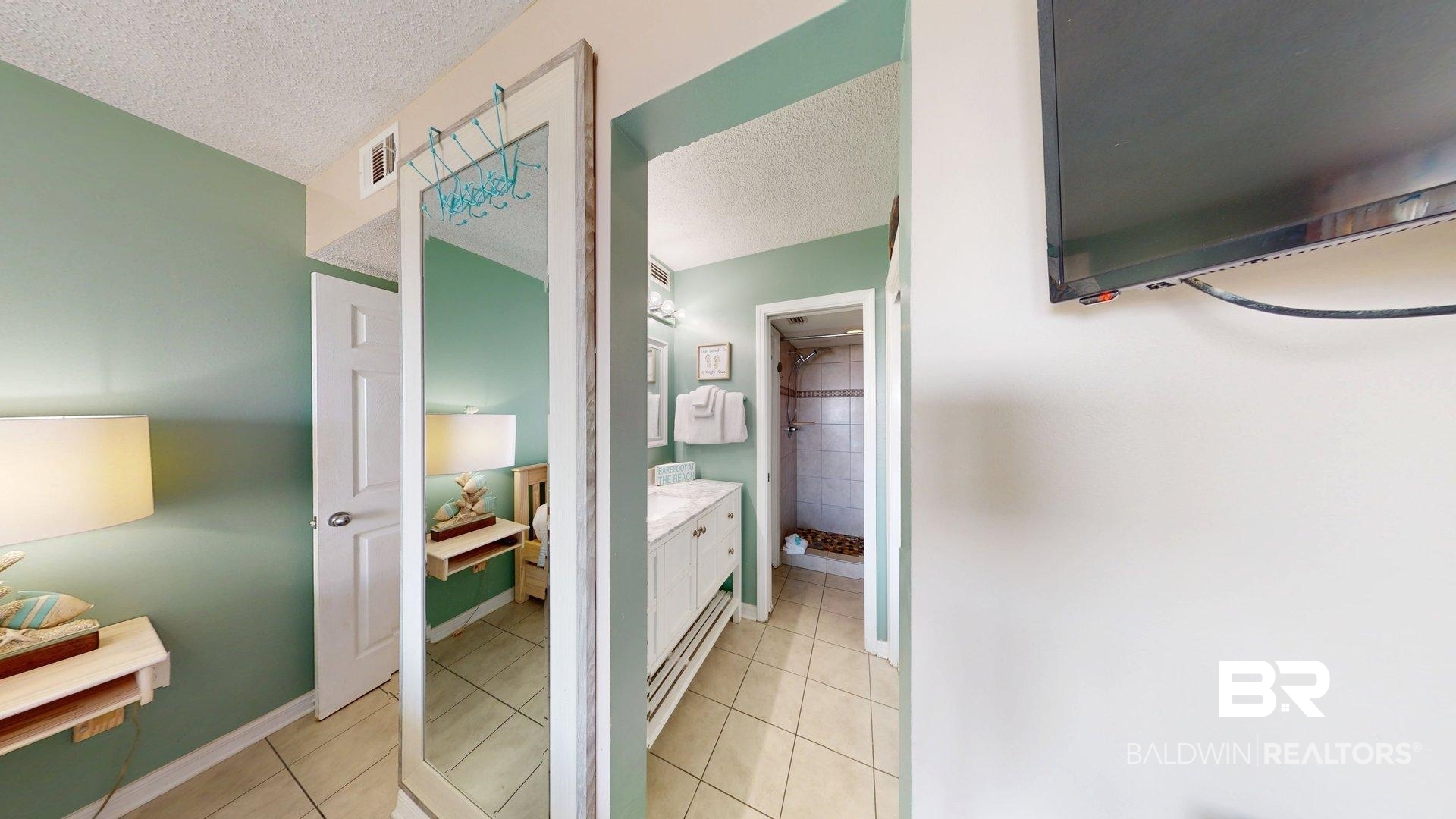 645 Plantation Road, Unit 6503 Gulf Shores, AL 36542 - Photo 39 of 53 Ensuite bathroom with light tile patterned flooring, a textured ceiling, vanity, and tiled shower