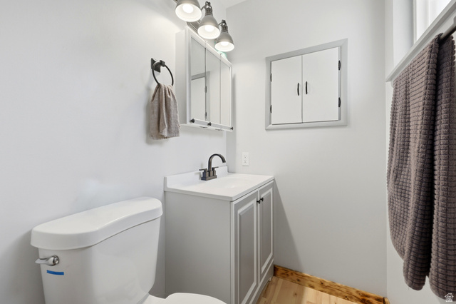 1486 3rd Street Ogden, UT 84404 - Photo 13 of 26 Bathroom featuring a white toilet, light gray vanity with white countertop, and a built-in medicine cabinet with a mirror