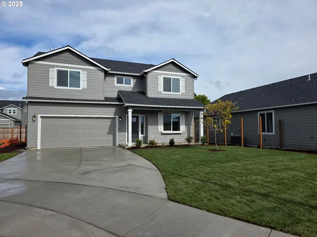 a front view of a house with a garden and trees
