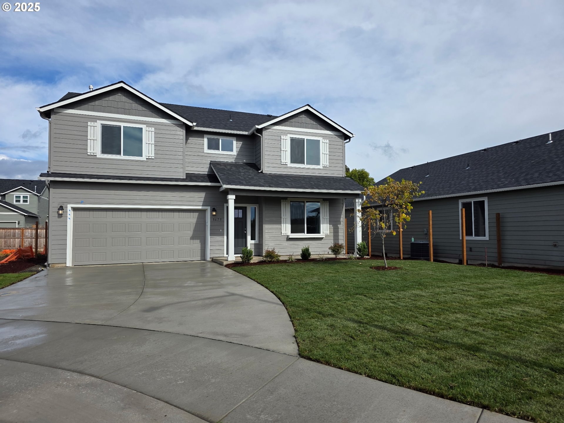 a front view of a house with a garden and trees