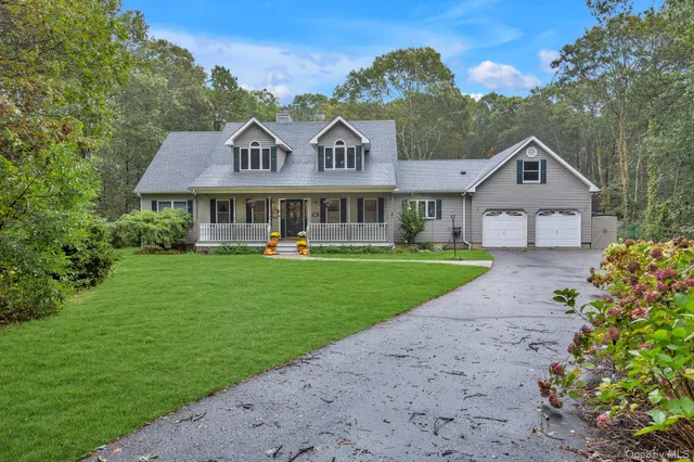a front view of a house with a garden and plants
