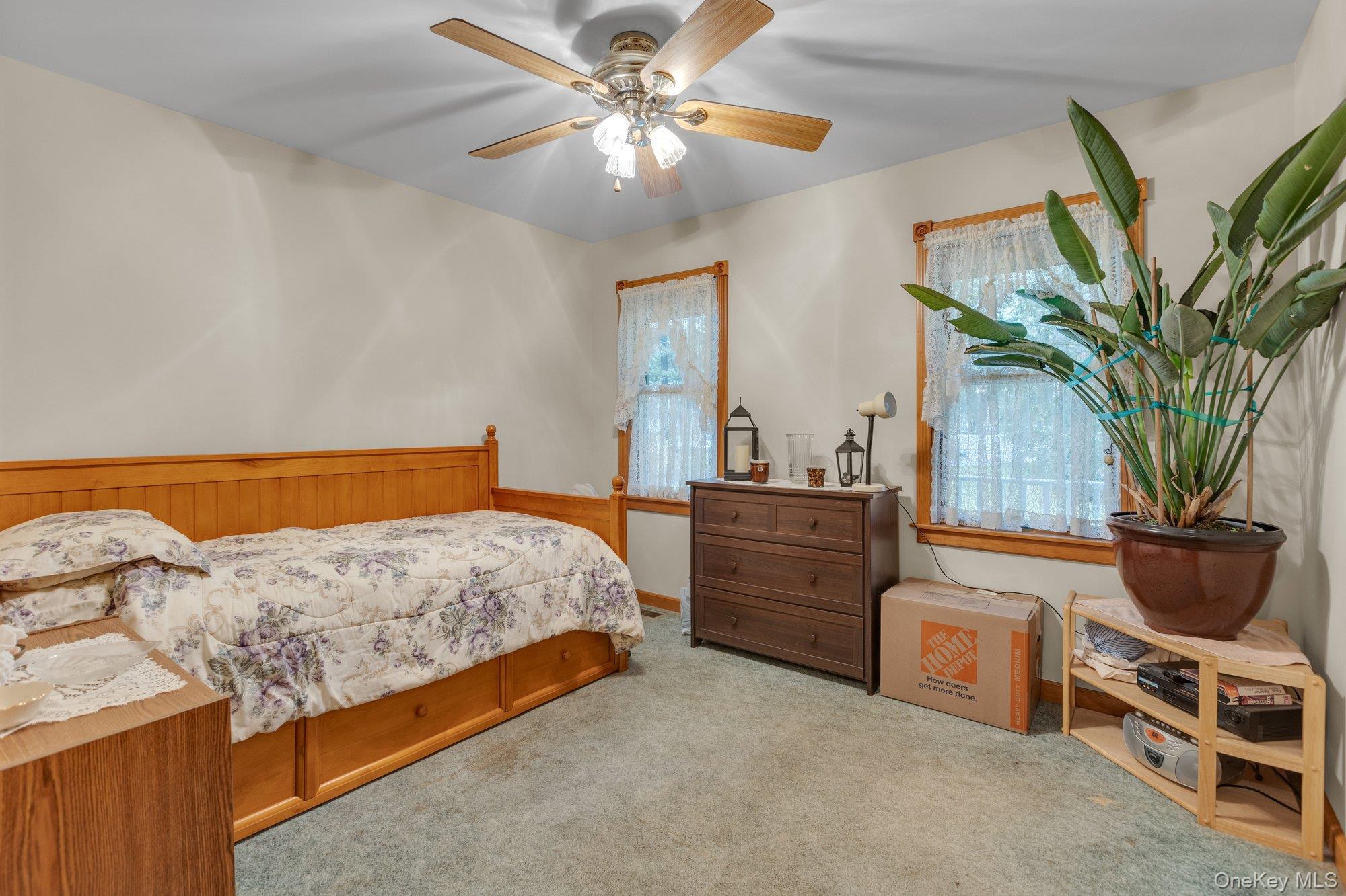 501 Wading River Road Manorville, NY 11949 - Photo 14 of 31 Bedroom featuring multiple windows, carpet floors, and a ceiling fan