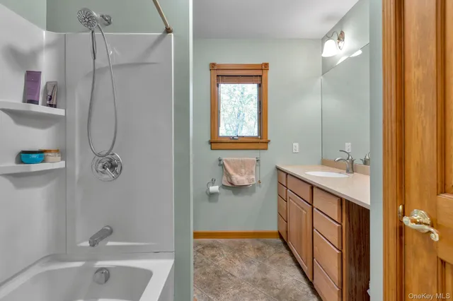 a bathroom with a tub sink and mirror