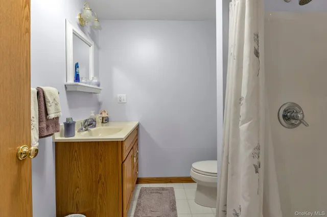 a bathroom with a granite countertop sink a toilet and a mirror