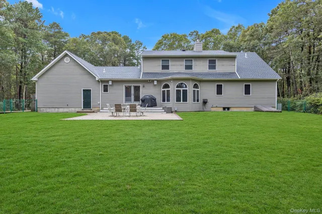 a front view of a house with garden and trees