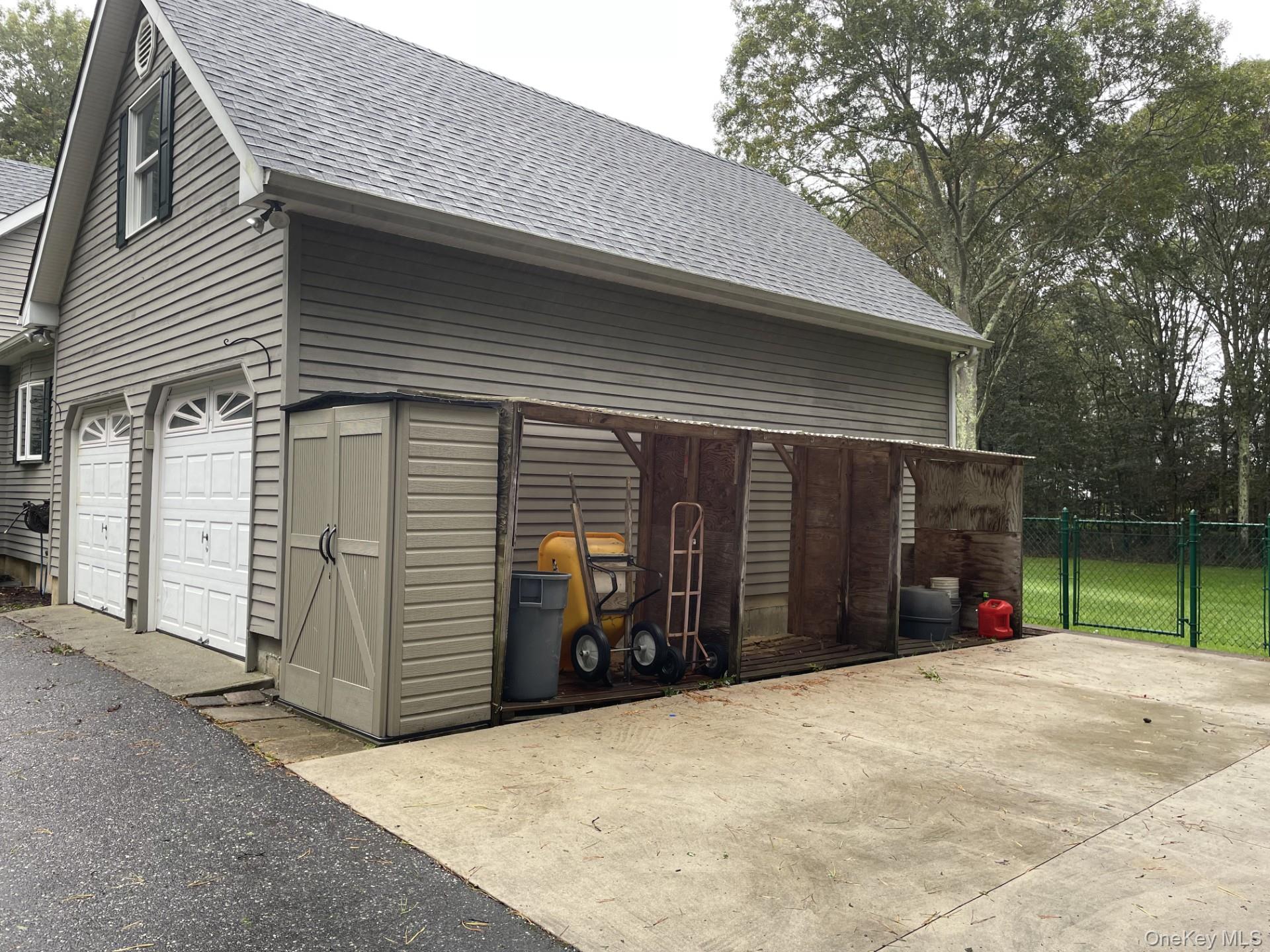 501 Wading River Road Manorville, NY 11949 - Photo 31 of 31 Garage featuring driveway and a gate
