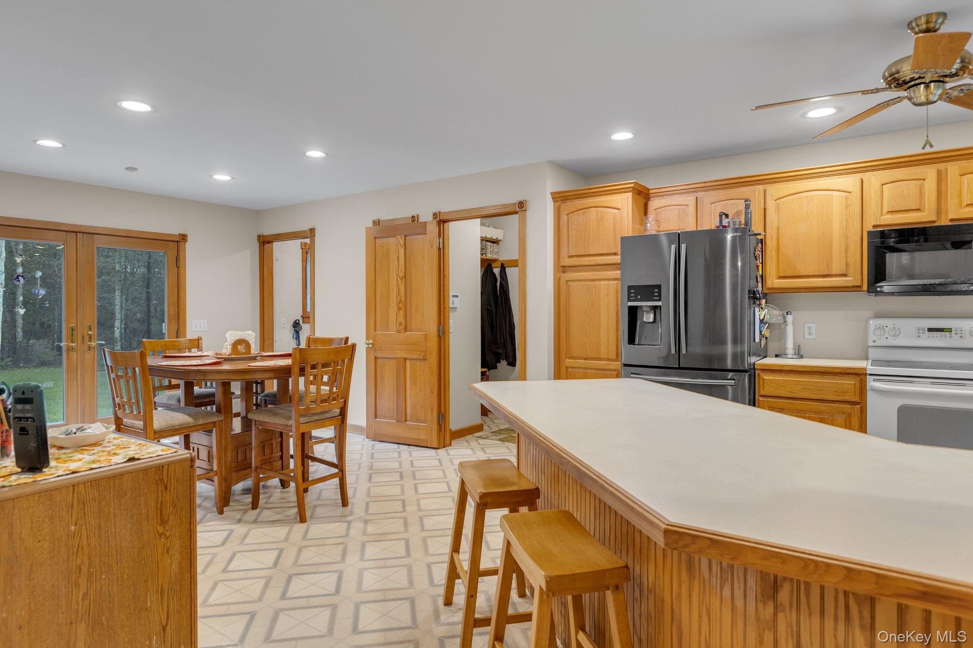 501 Wading River Road Manorville, NY 11949 - Photo 7 of 31 Kitchen with light countertops, fridge with ice dispenser, light flooring, recessed lighting, and electric stove