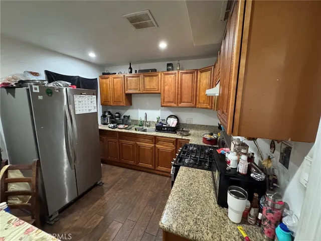 a kitchen with stainless steel appliances granite countertop a refrigerator stove and sink