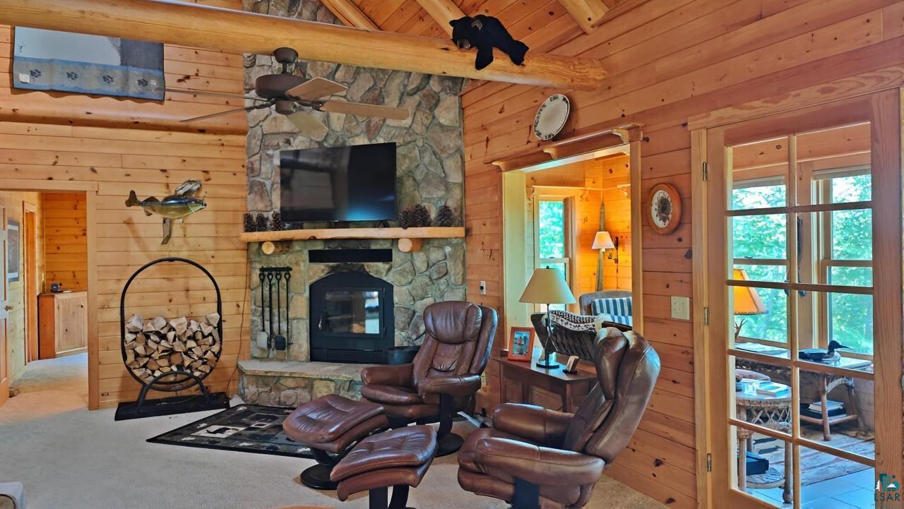 2357 Retreat Lodge Road Cook, MN 55723 - Photo 4 of 60 Carpeted living area featuring wooden walls, a ceiling fan, a fireplace, and wood ceiling