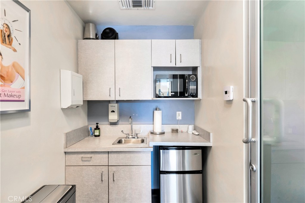 24691 Del Prado Avenue Dana Point, CA 92629 - Photo 65 of 67 a kitchen with stainless steel appliances a refrigerator sink and cabinets