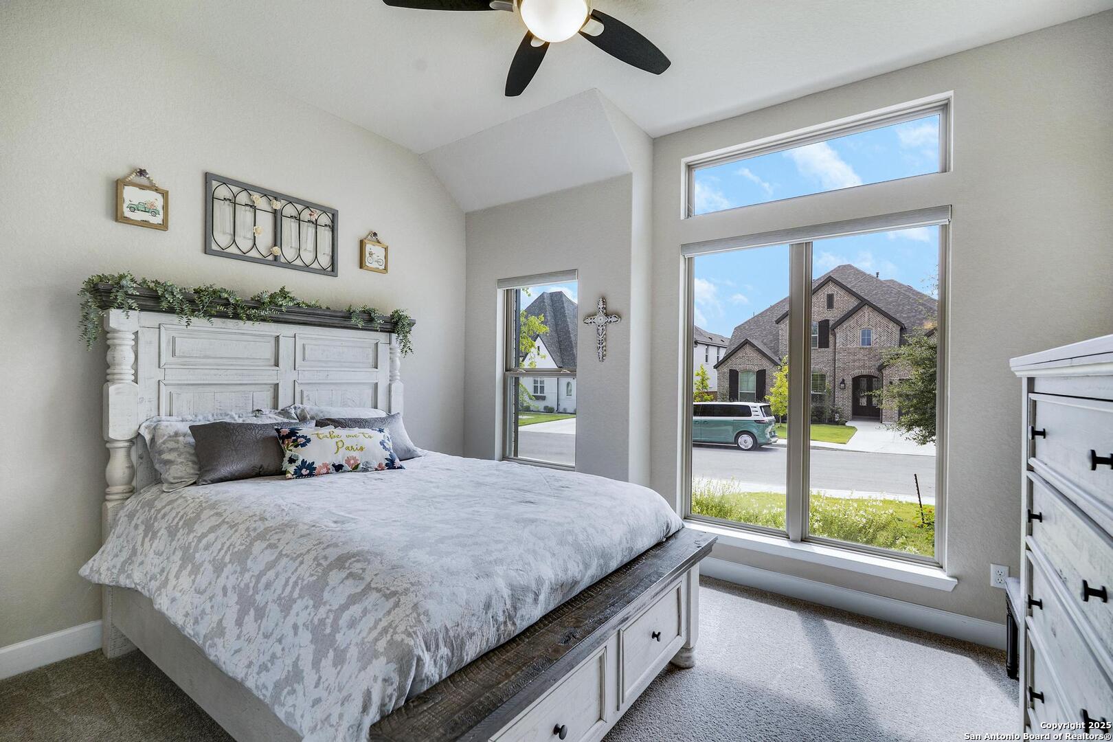 10027 Sarah Place Boerne, TX 78006 - Photo 26 of 47 a bedroom with a large bed and a chandelier