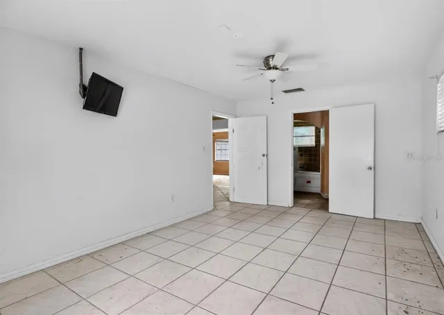 a view of an empty room with a ceiling fan