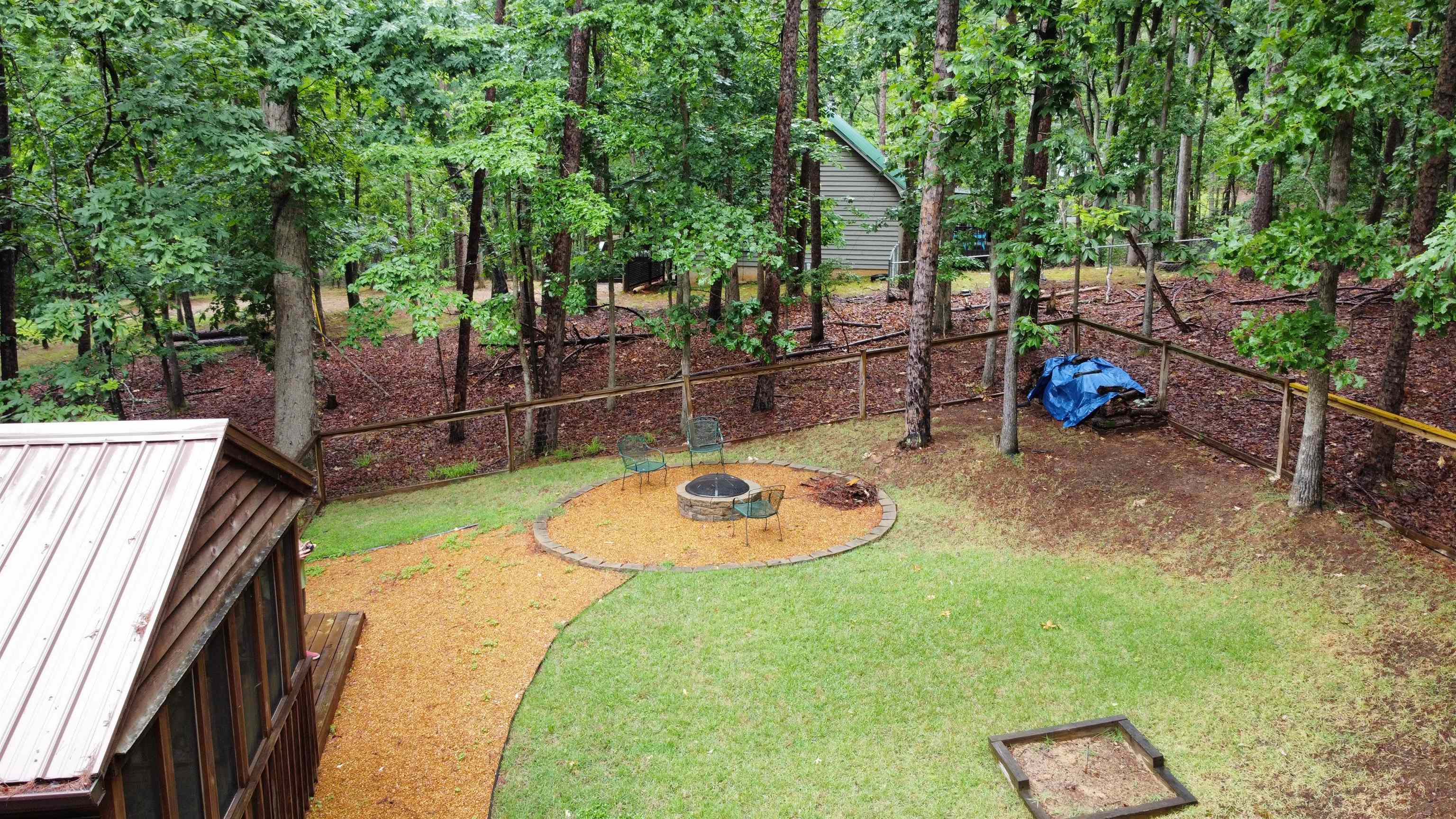 275 Bryson Harbor Road Counce, TN 38326 - Photo 7 of 23 Wooded outdoor area featuring a stone fire pit with surrounding gravel and a defined lawn section