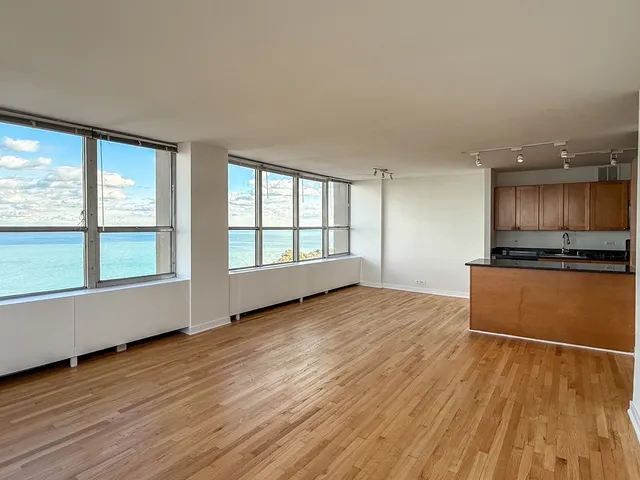 a view of a kitchen with wooden floor and electronic appliances