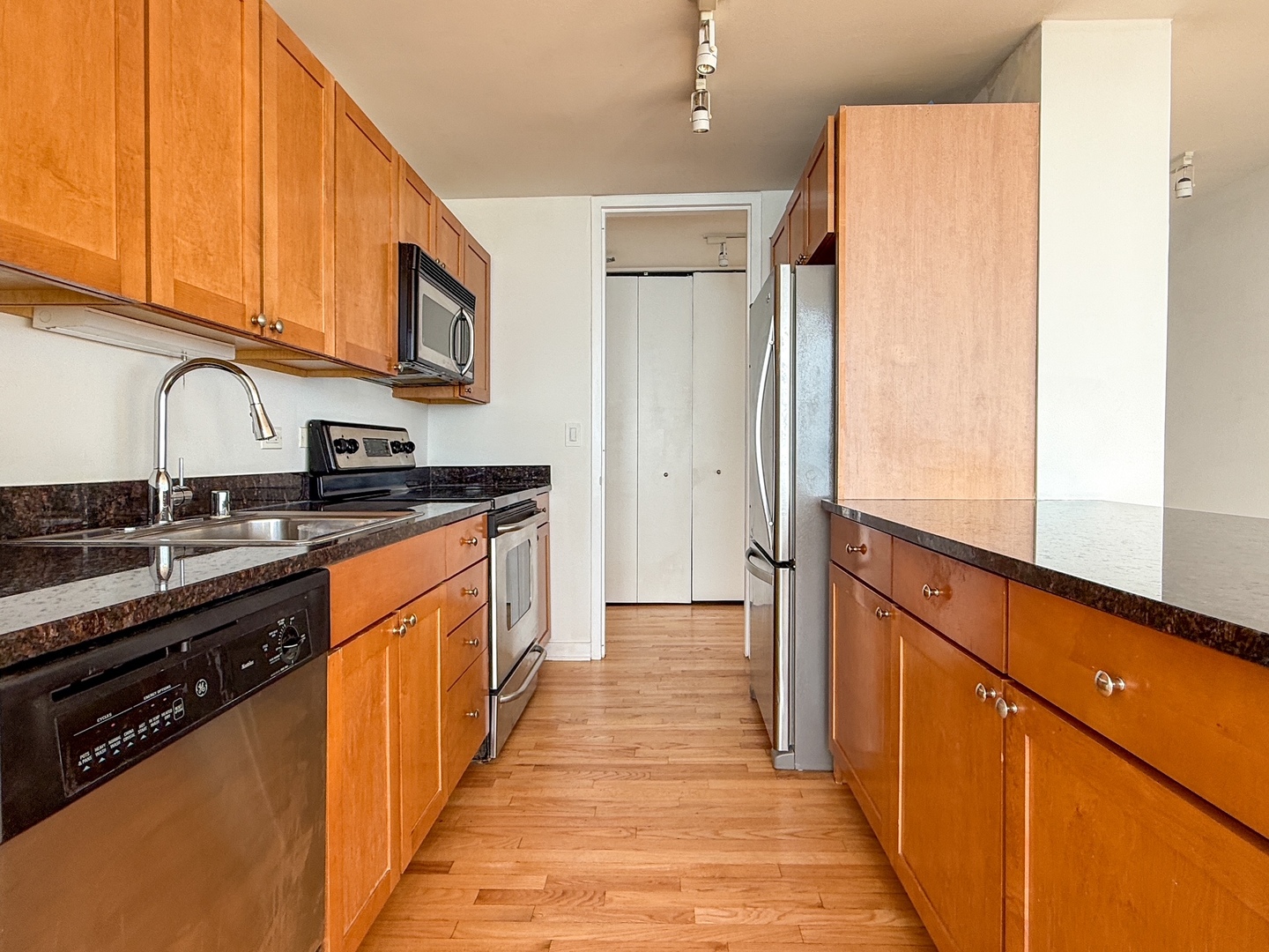 655 West Irving Park Road, Unit 4702 Chicago, IL 60613 - Photo 6 of 17 a kitchen with stainless steel appliances granite countertop a sink and wooden cabinets