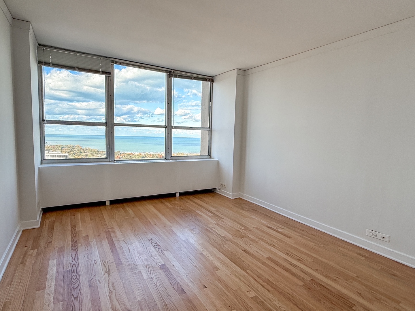 655 West Irving Park Road, Unit 4702 Chicago, IL 60613 - Photo 10 of 17 an empty room with wooden floor and windows