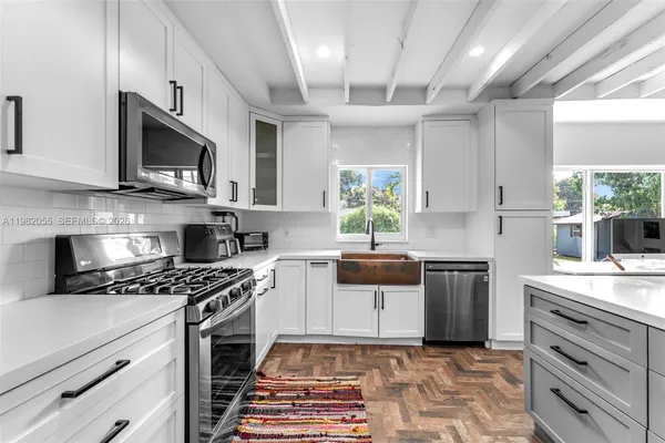 a kitchen with granite countertop a sink appliances and cabinets