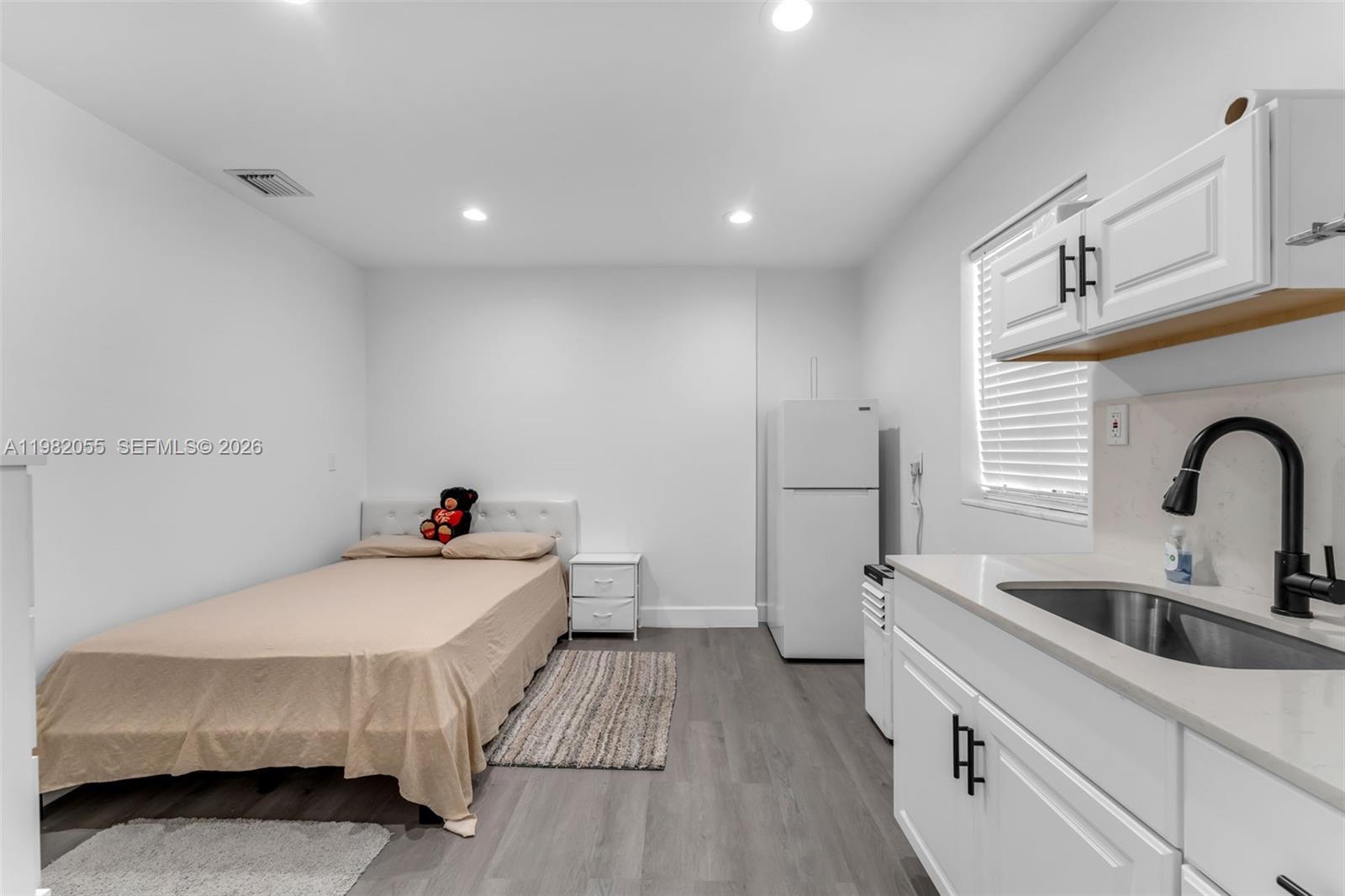149 Fern Way Miami Springs, FL 33166 - Photo 15 of 35 a kitchen with a sink and a wooden floor