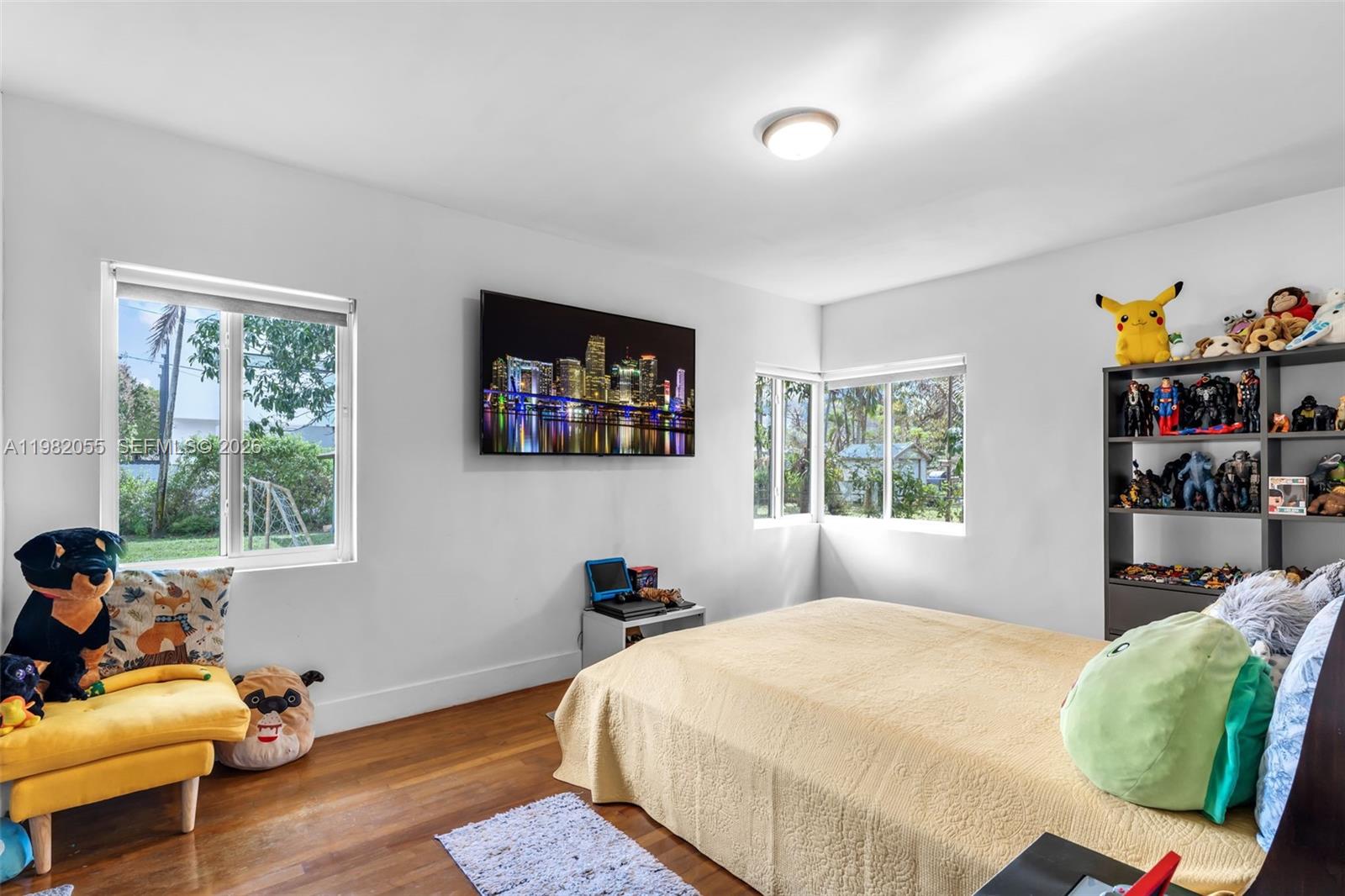 149 Fern Way Miami Springs, FL 33166 - Photo 18 of 35 a bedroom with a bed and wooden floor