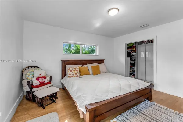 a bedroom with a bed and wooden floor