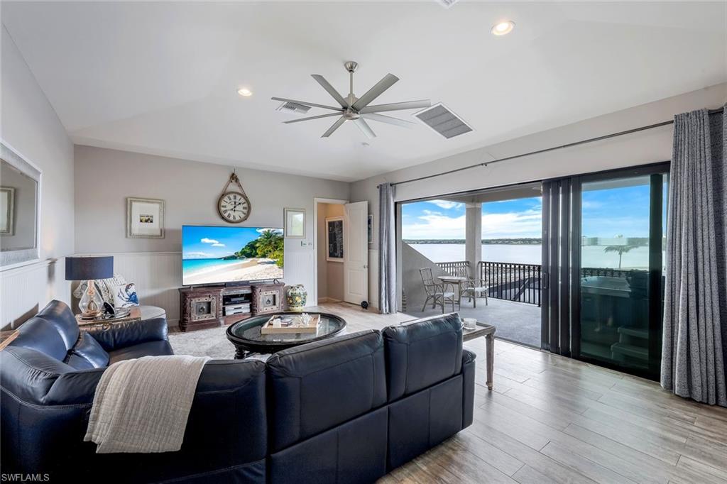 9206 Marble Stone Drive Naples, FL 34120 - Photo 13 of 50 a living room with furniture a flat screen tv and a large window