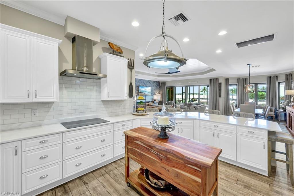 9206 Marble Stone Drive Naples, FL 34120 - Photo 17 of 50 a open kitchen with kitchen island white cabinets and stainless steel appliances
