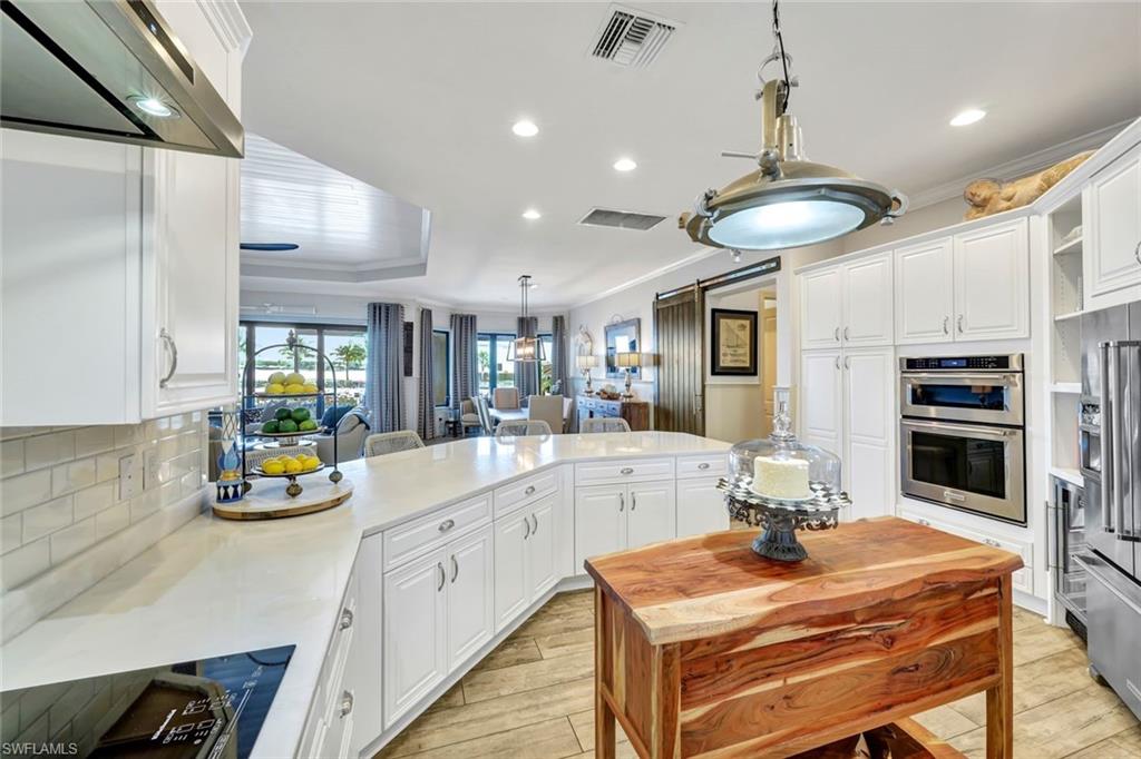 9206 Marble Stone Drive Naples, FL 34120 - Photo 18 of 50 a kitchen with stainless steel appliances kitchen island granite countertop a sink and cabinets
