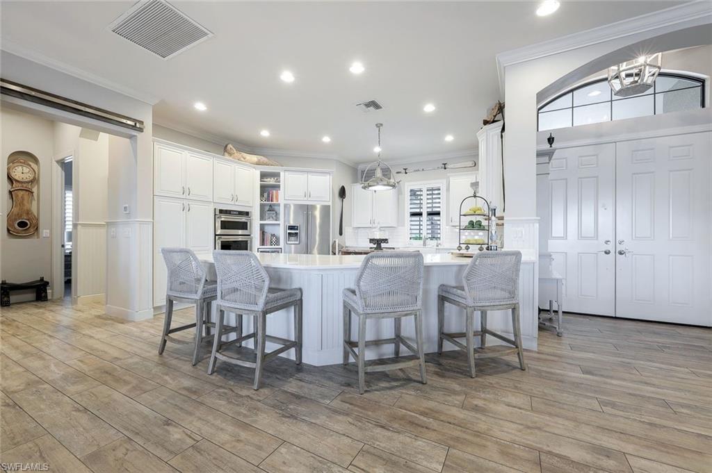 9206 Marble Stone Drive Naples, FL 34120 - Photo 20 of 50 a large kitchen with a table and chairs