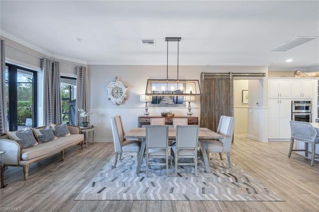 a dining room with furniture a chandelier and wooden floor