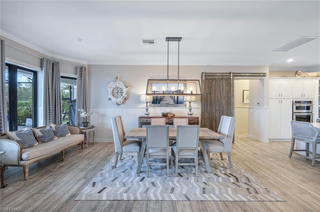 9206 Marble Stone Drive Naples, FL 34120 - Photo 22 of 50 a dining room with furniture a chandelier and wooden floor