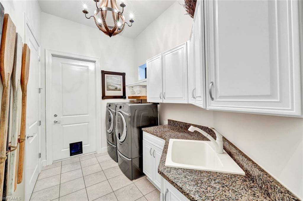 9206 Marble Stone Drive Naples, FL 34120 - Photo 32 of 50 a kitchen with a refrigerator a washer and dryer